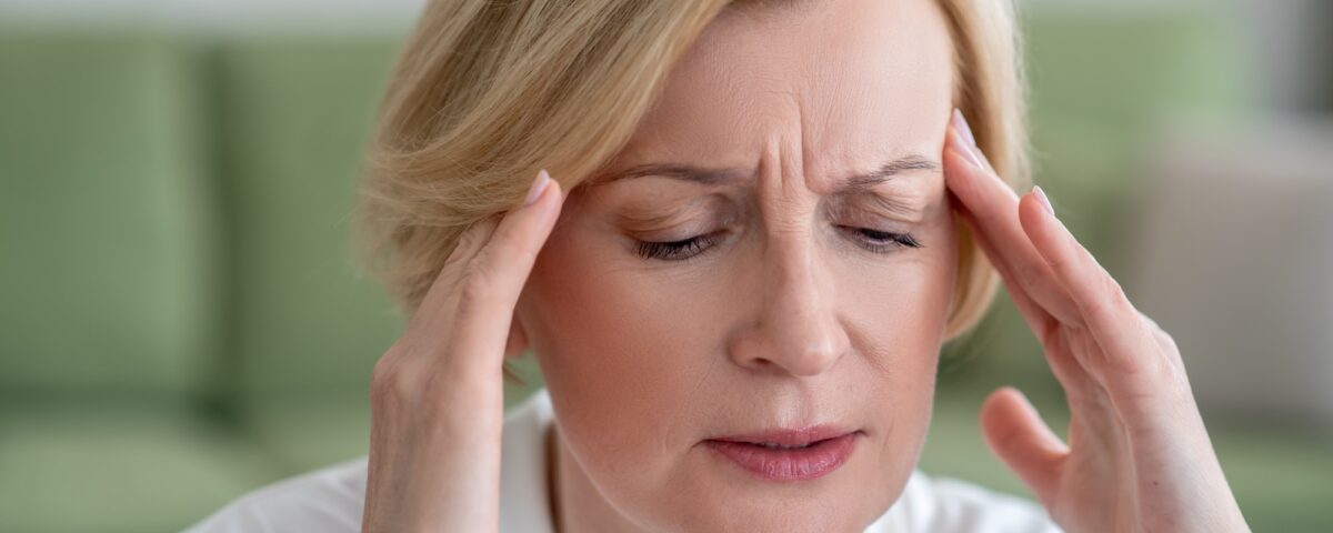 Midaged blone woman suffering from a headache