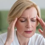 Midaged blone woman suffering from a headache