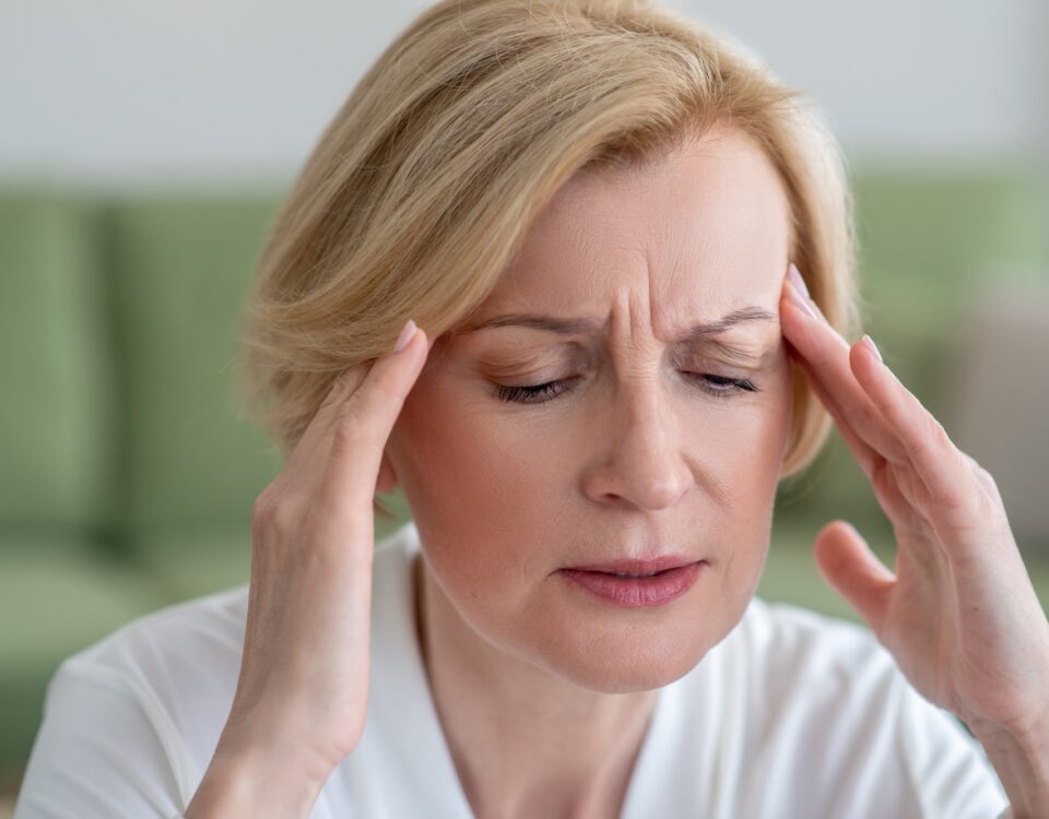 Midaged blone woman suffering from a headache