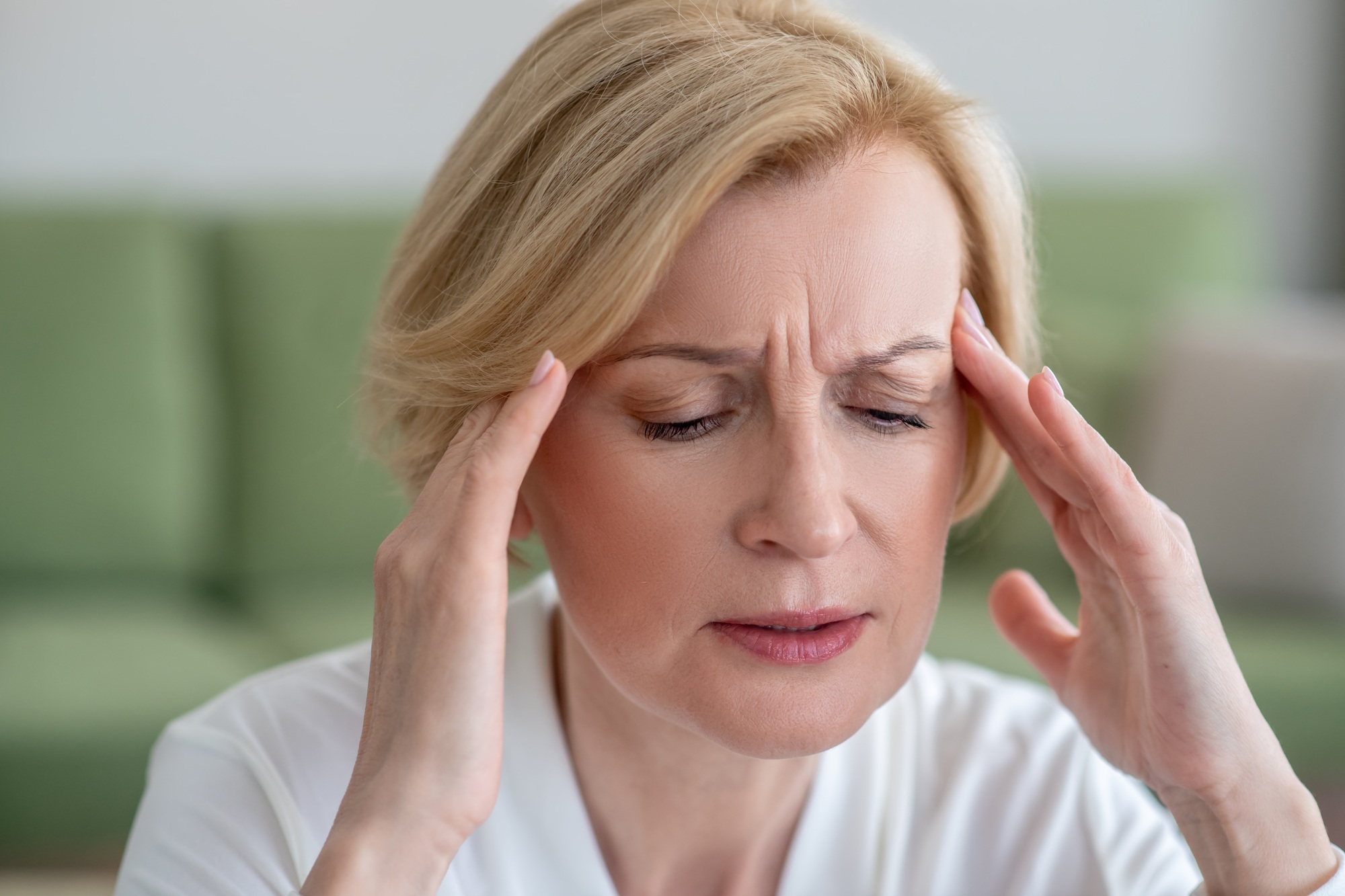 Midaged blone woman suffering from a headache